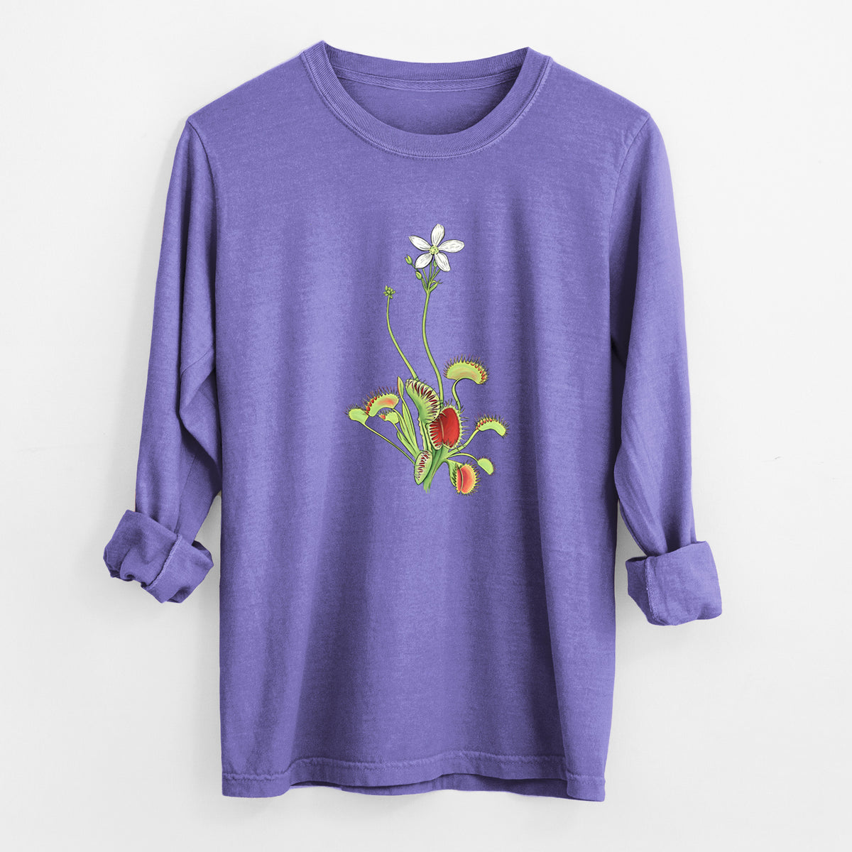 Violet purple Comfort Colors long sleeve shirt laid flat with the cuffs rolled, printed with a full-color illustration of a Venus flytrap plant with red traps and a small white flower.