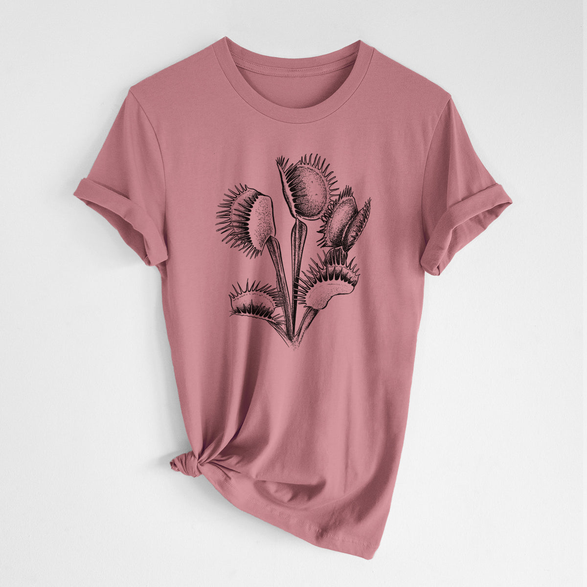 Mauve pink lightweight cotton t-shirt laid flat with the sleeves rolled, printed with a black ink illustration of a Venus flytrap plant with open traps.