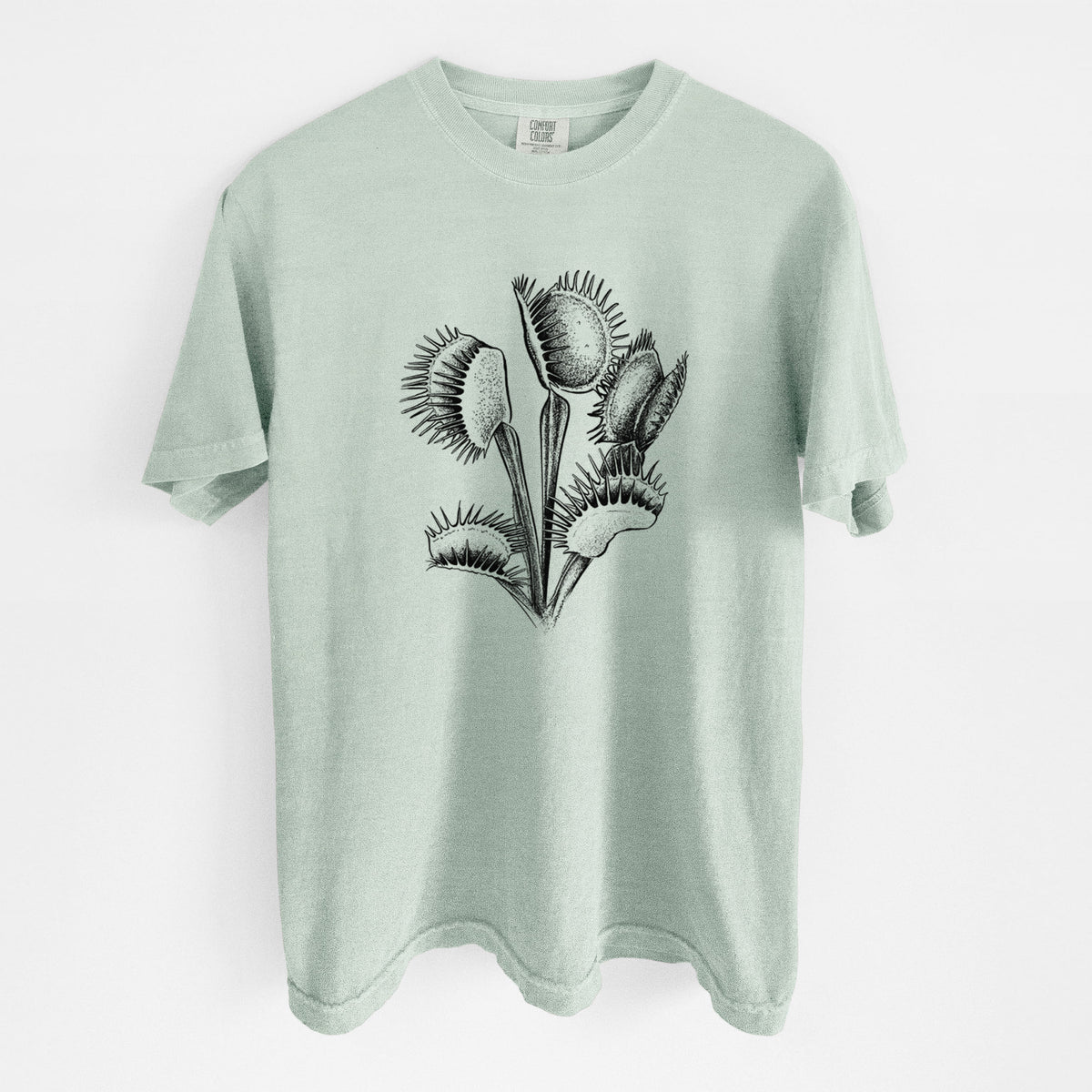 Bay green Comfort Colors t-shirt laid flat, printed with a black ink illustration of a Venus flytrap plant with open traps.