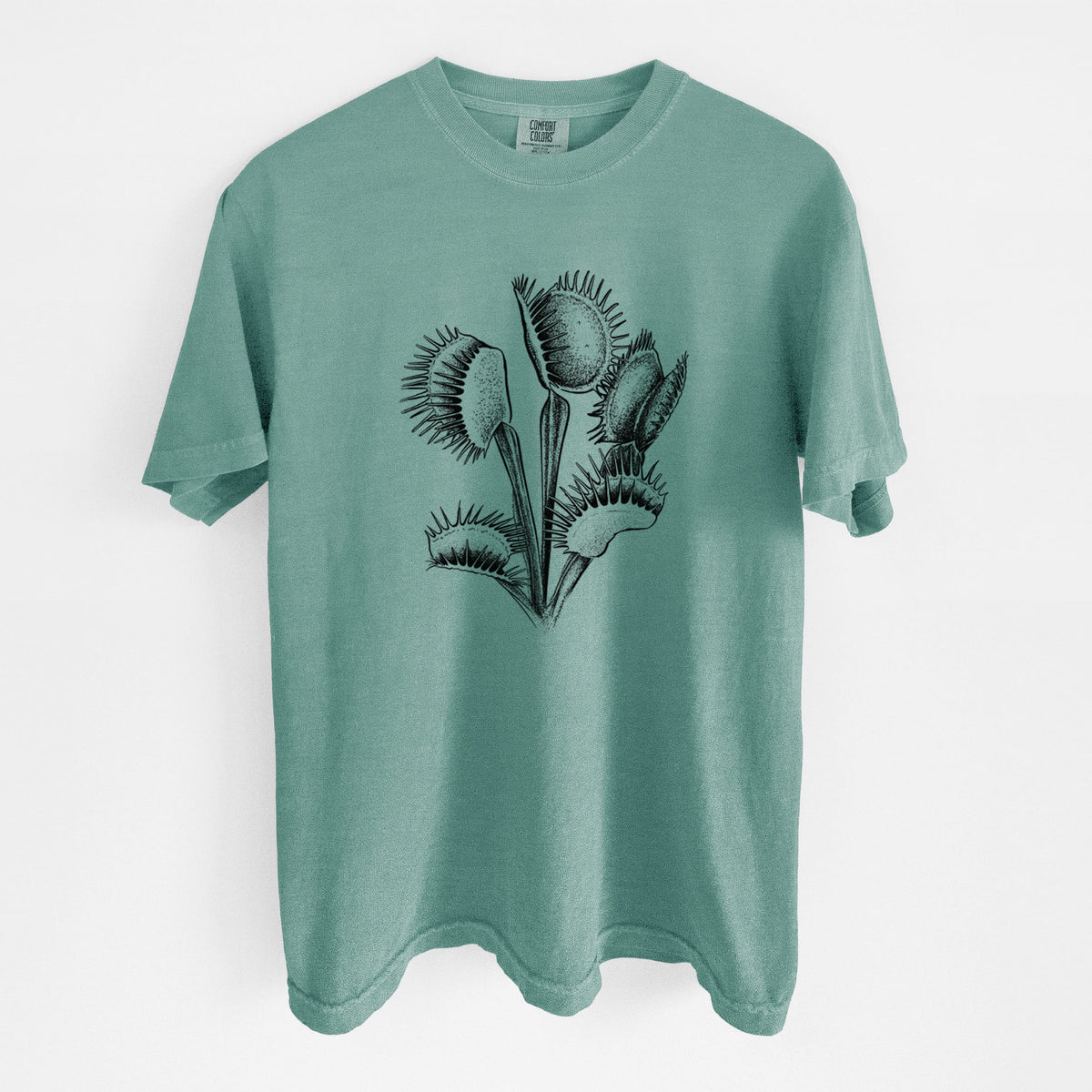 Reef green Comfort Colors t-shirt laid flat, printed with a black ink illustration of a Venus flytrap plant with open traps.