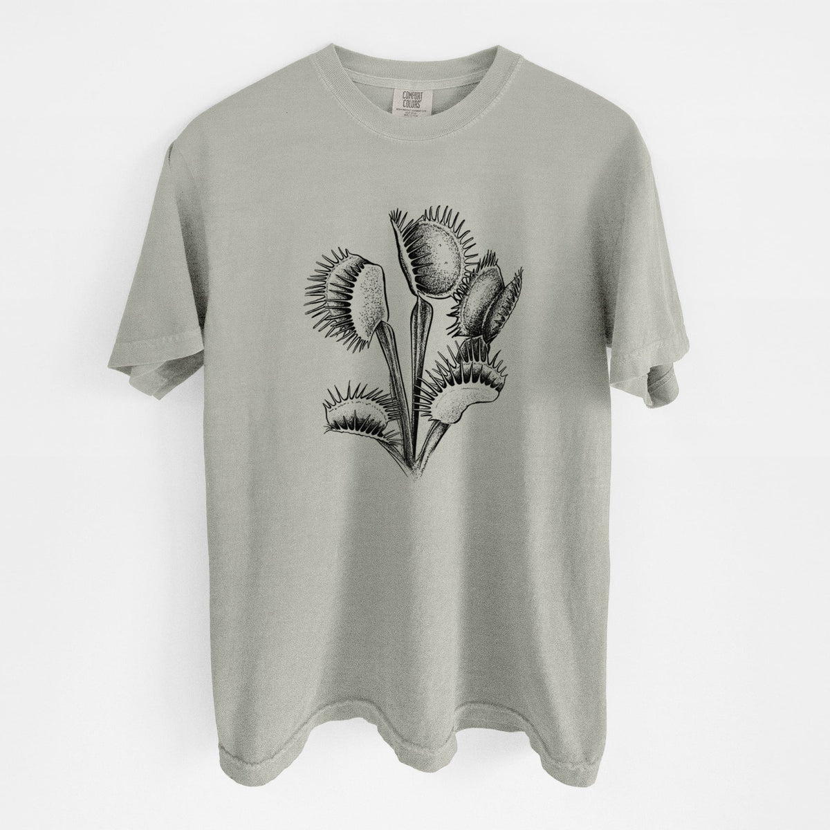 Sandstone beige Comfort Colors t-shirt laid flat, printed with a black ink illustration of a Venus flytrap plant with open traps.