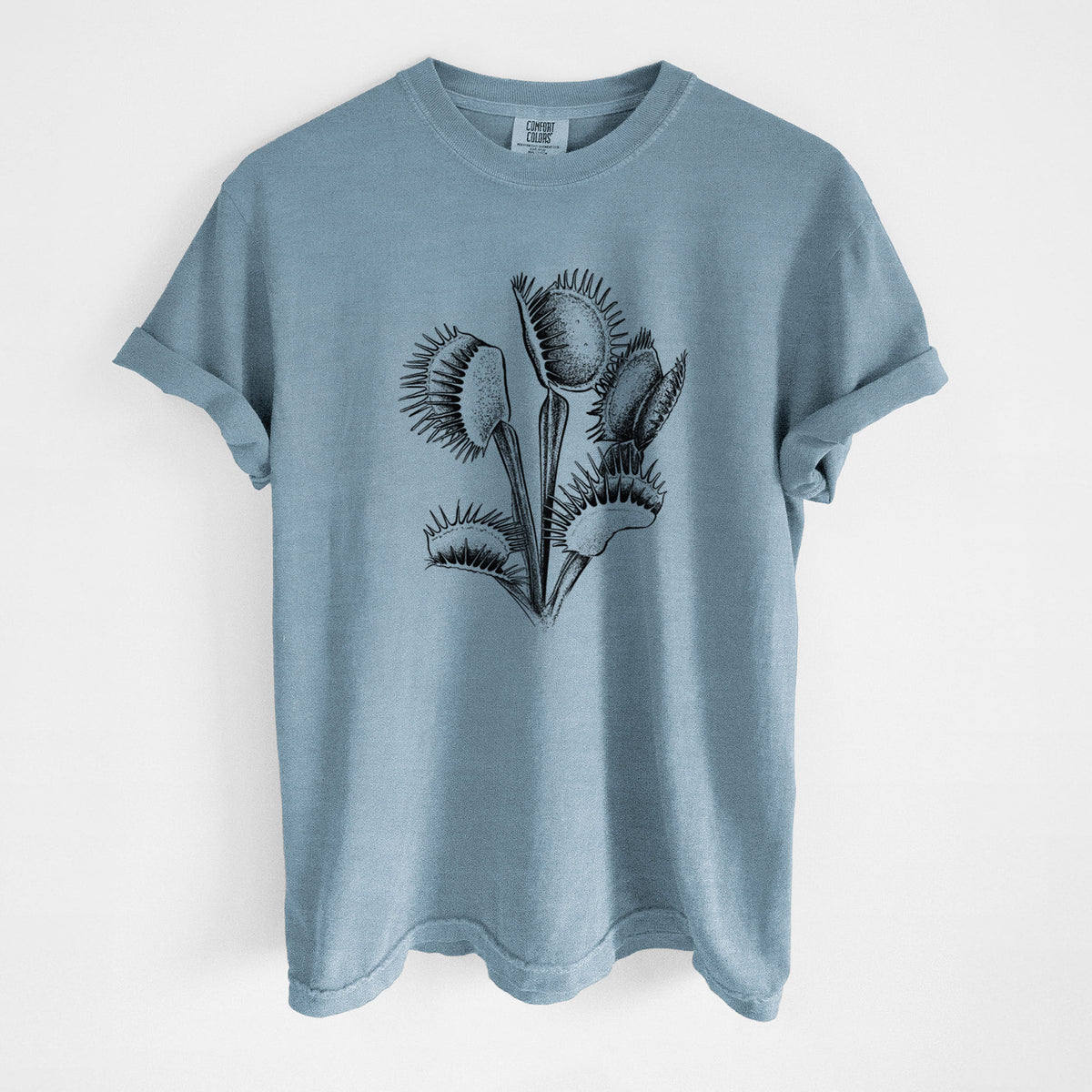 Steel blue Comfort Colors t-shirt laid flat, printed with a black ink illustration of a Venus flytrap plant with open traps.