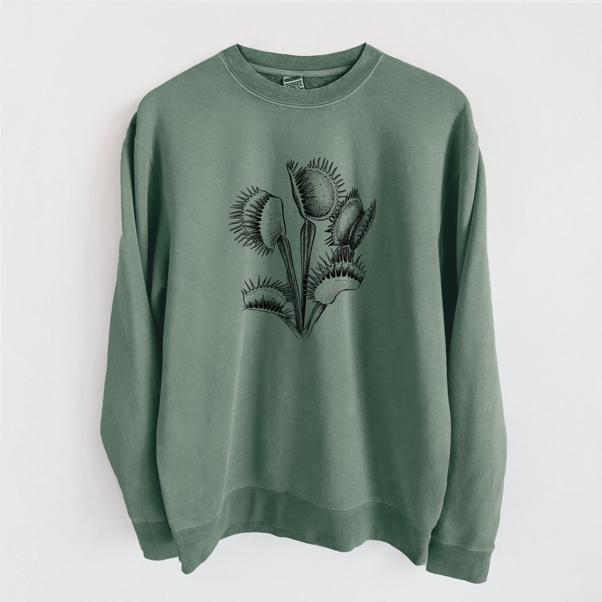 Alpine green pigment dyed crewneck sweatshirt laid flat, printed with a black ink illustration of a Venus flytrap plant with open traps.