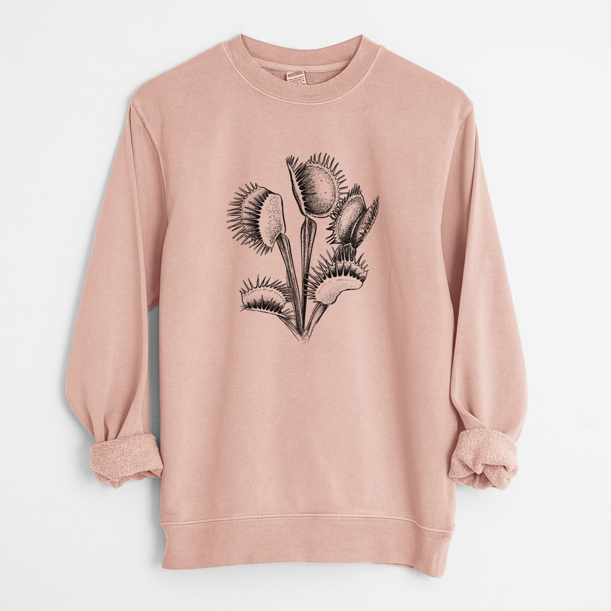 Dusty pink pigment dyed crewneck sweatshirt laid flat with the sleeves rolled, printed with a black ink illustration of a Venus flytrap plant with open traps.