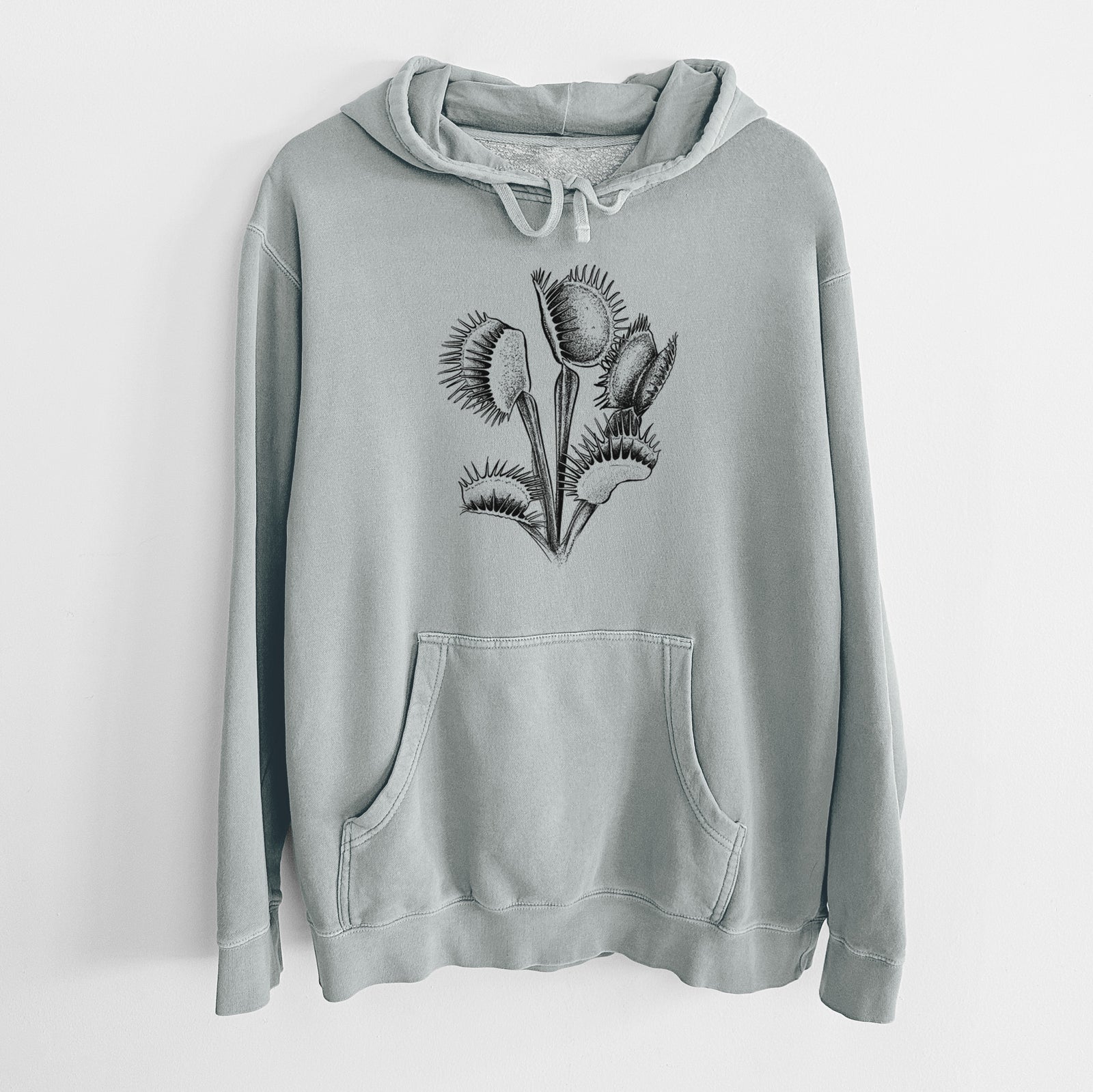 Sage green pigment dyed hoodie laid flat, printed with a black ink illustration of a Venus flytrap plant with open traps.
