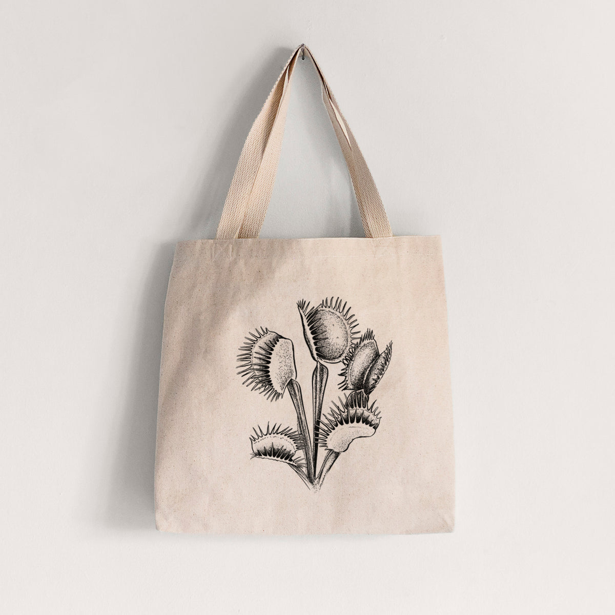 Natural canvas tote bag printed with a black ink illustration of a Venus flytrap plant with open traps.
