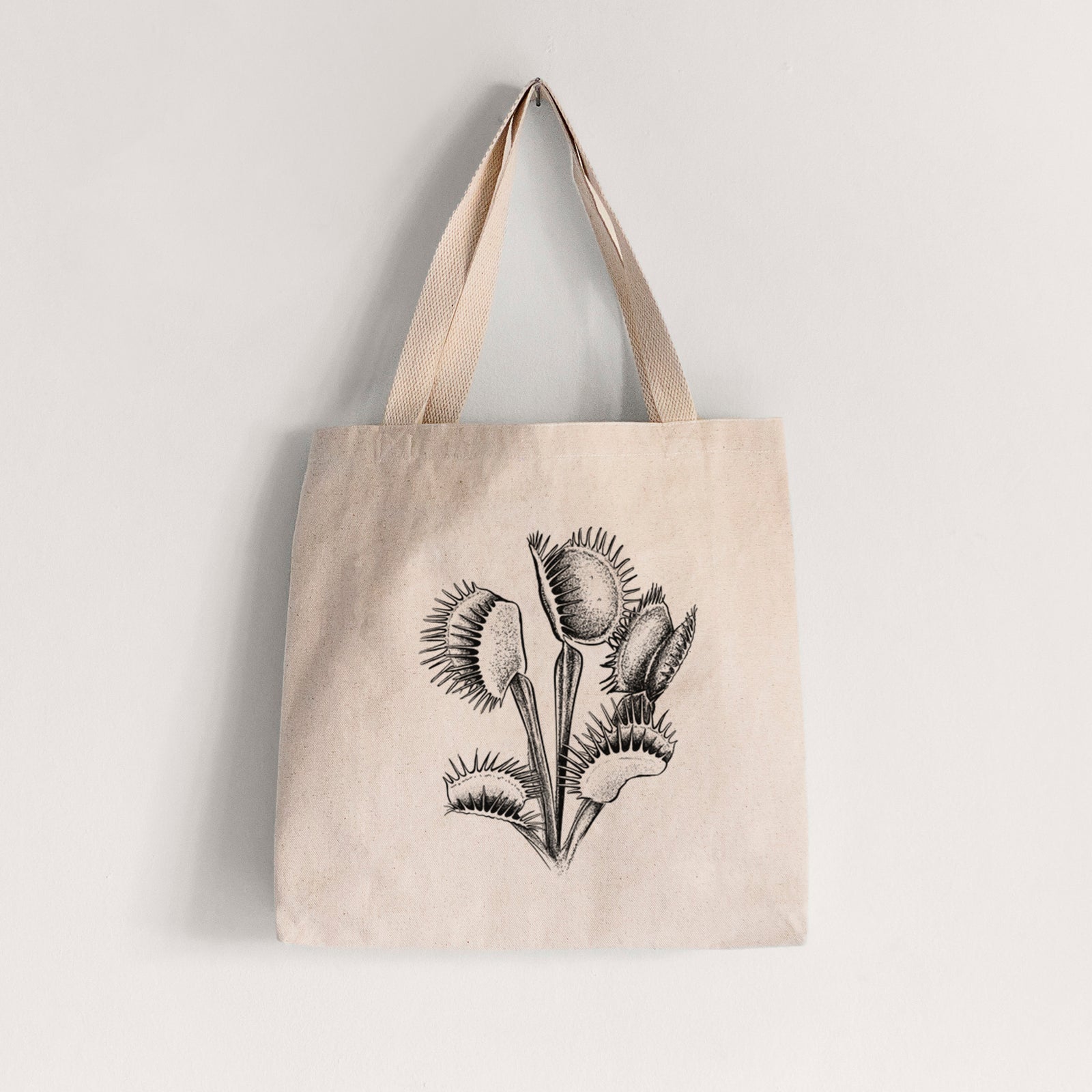 Natural canvas tote bag printed with a black ink illustration of a Venus flytrap plant with open traps.