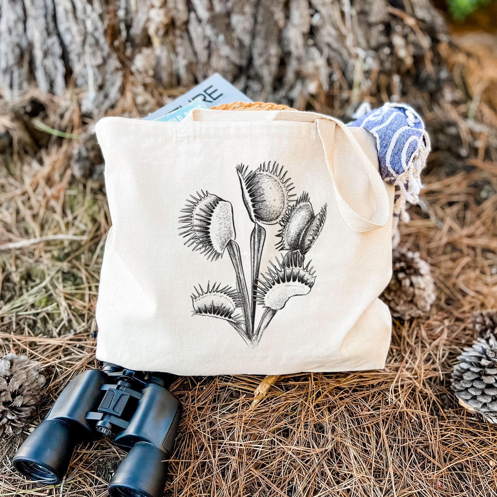 Natural canvas tote bag printed with a black ink illustration of a Venus flytrap plant with open traps.