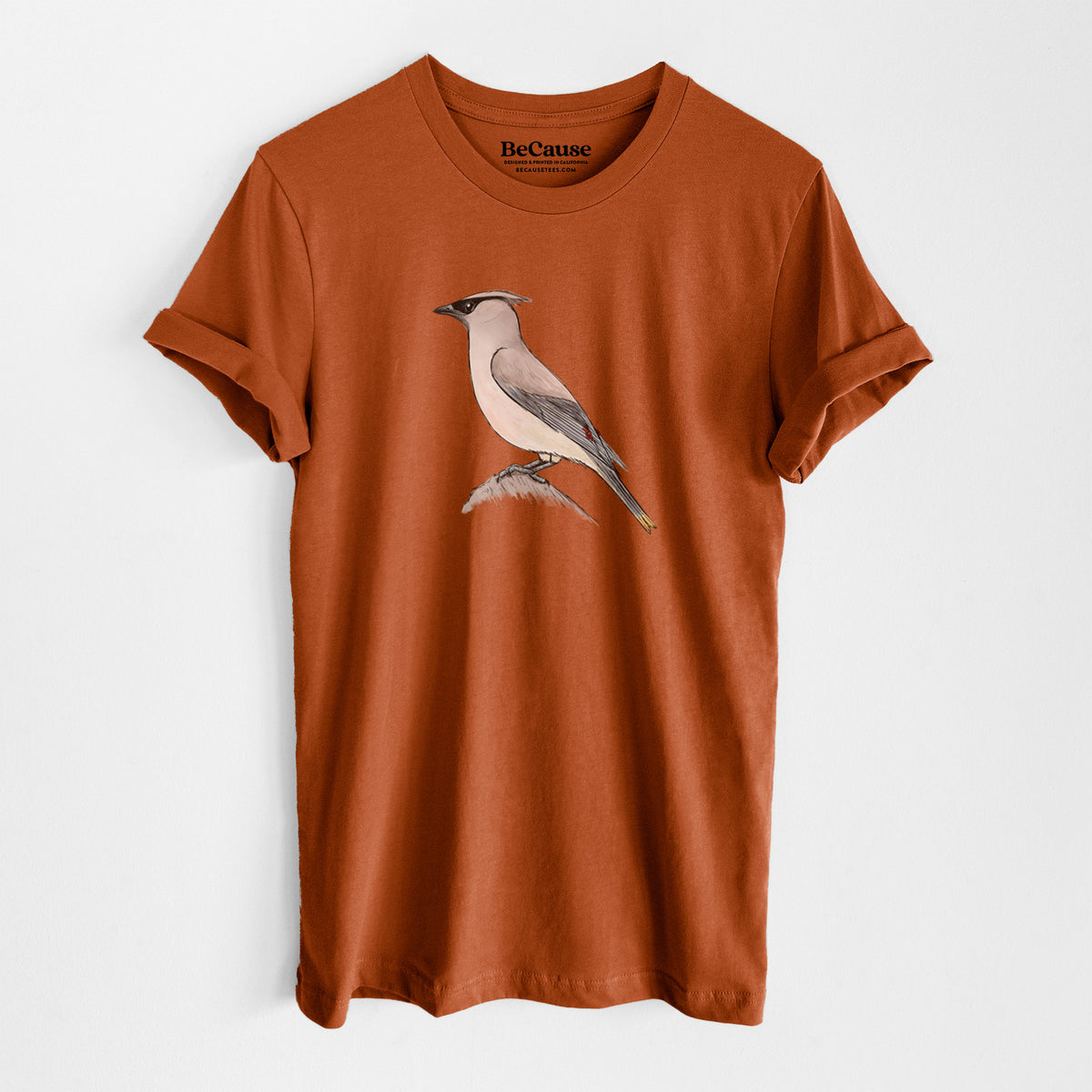 Autumn lightweight cotton t-shirt laid flat, printed with a full-color illustration of a cedar waxwing perched on a branch.