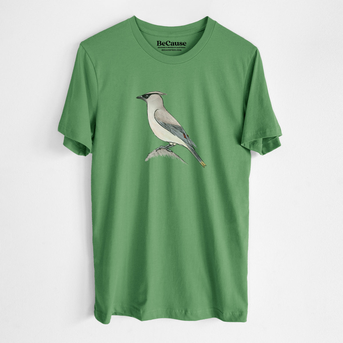 Leaf green lightweight cotton t-shirt laid flat, printed with a full-color illustration of a cedar waxwing perched on a branch.
