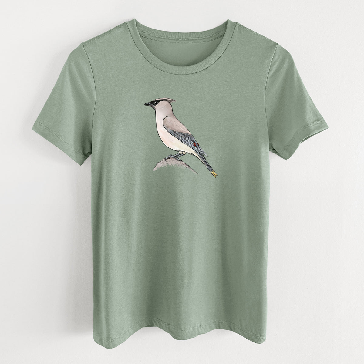 Sage green women's relaxed fit cotton t-shirt laid flat, printed with a full-color illustration of a cedar waxwing perched on a branch.