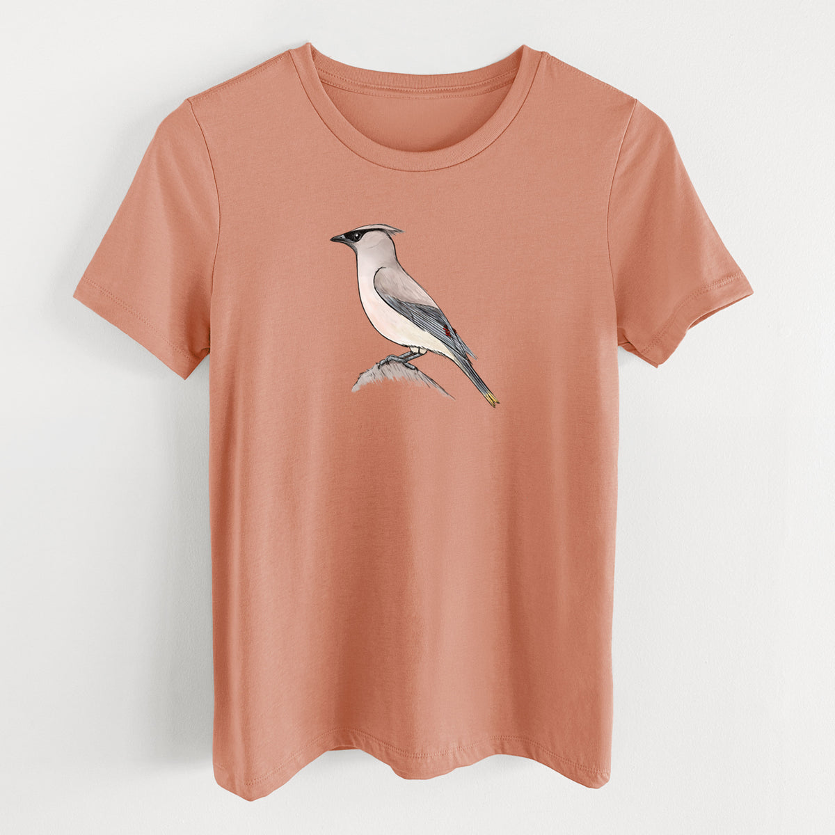 Terracotta orange women's relaxed fit cotton t-shirt laid flat, printed with a full-color illustration of a cedar waxwing perched on a branch.