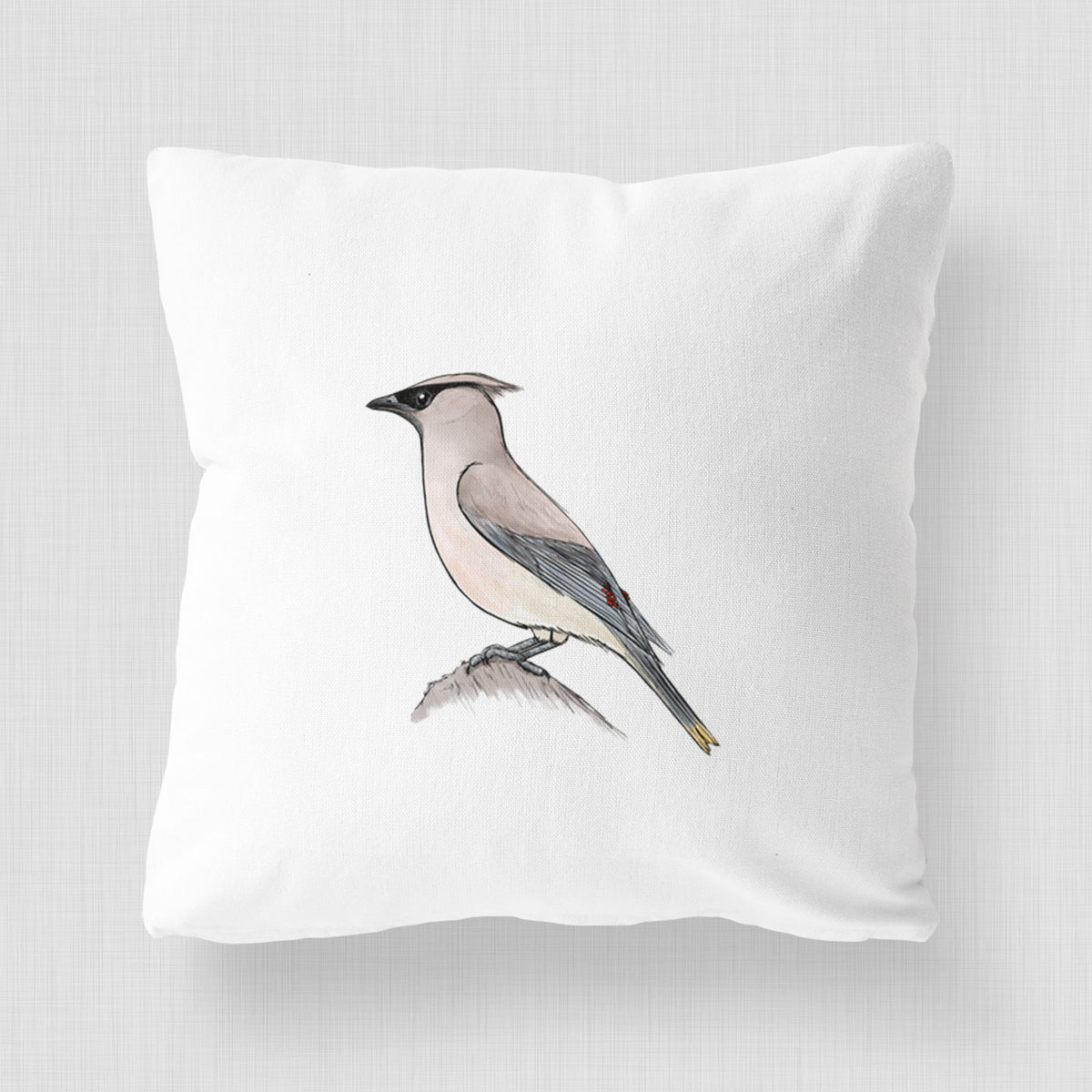 White pillow cover printed with a full-color illustration of a cedar waxwing perched on a branch.