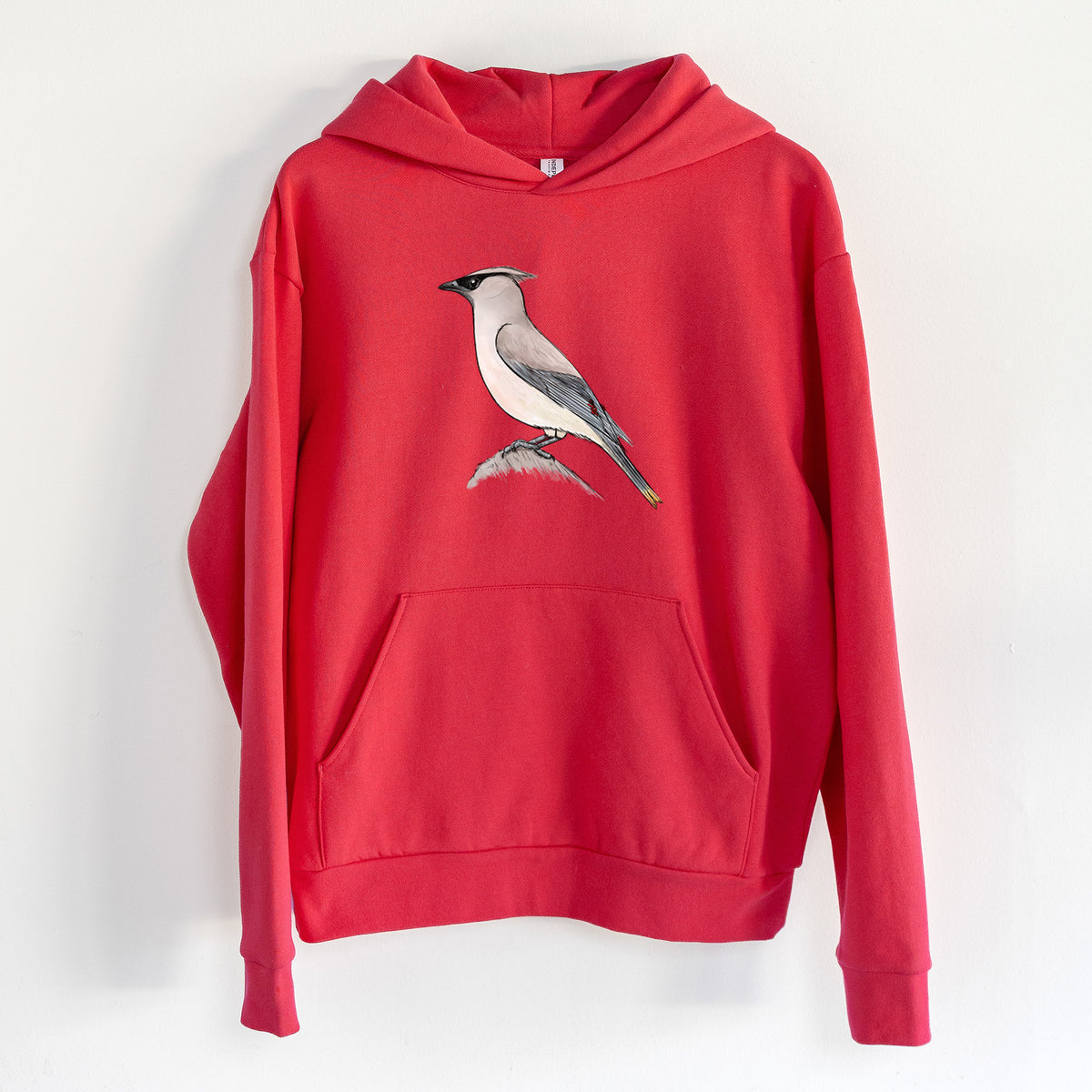 Vibrant Cedar Waxwing - Bombycilla cedrorum - Statement Midweight Hoodie in Cherry Red, hanging on a white wall, with a front kangaroo pocket and no drawcords.