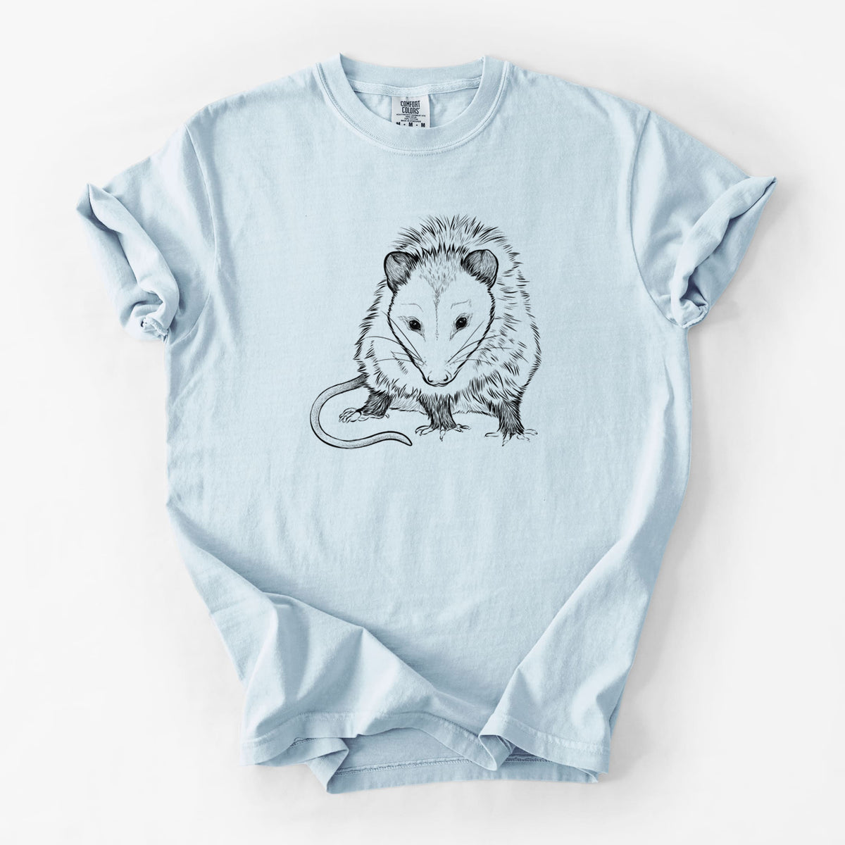 Chambray blue Comfort Colors t-shirt laid flat, printed with a detailed black ink illustration of a Virginia opossum standing with its long tail curled.