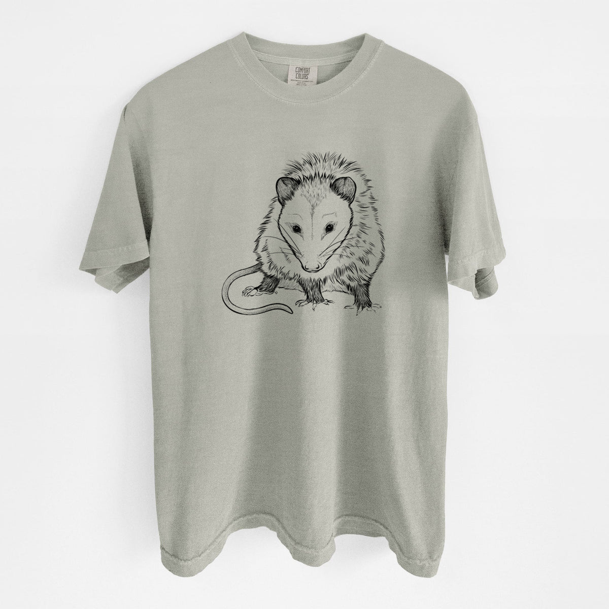Sandstone beige Comfort Colors t-shirt laid flat, printed with a detailed black ink illustration of a Virginia opossum standing with its long tail curled.
