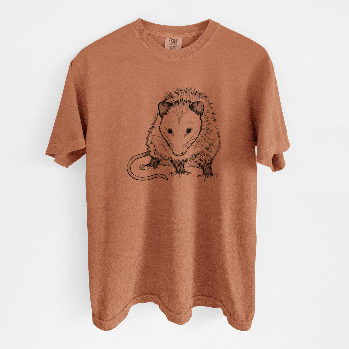 Yam burnt orange Comfort Colors t-shirt laid flat, printed with a detailed black ink illustration of a Virginia opossum standing with its long tail curled.
