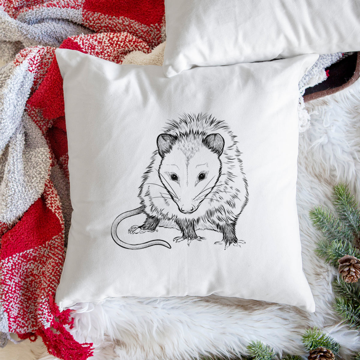 White pillow cover printed with a detailed black ink illustration of a Virginia opossum standing with its long tail curled, on a woven chair.