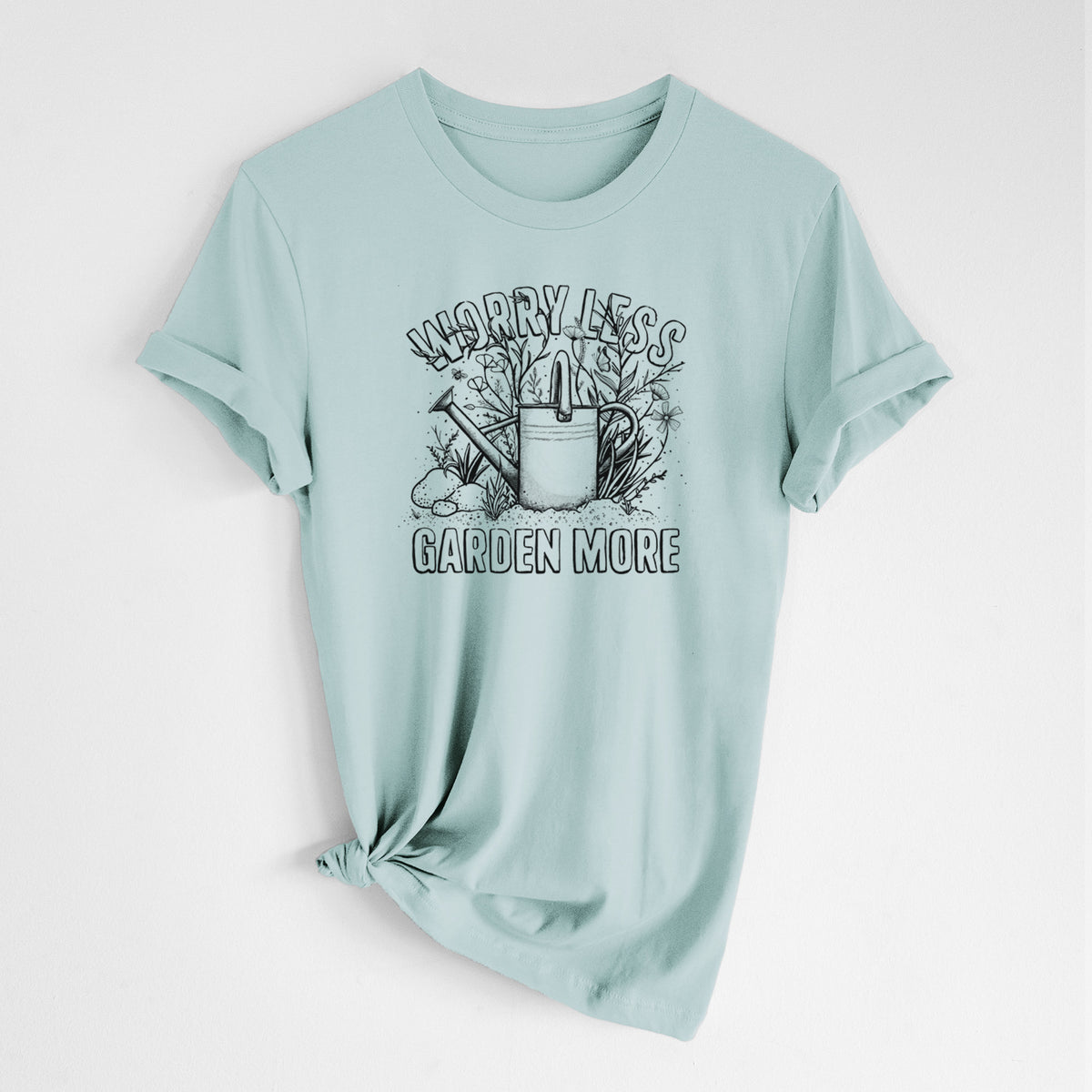 Dusty blue lightweight cotton t-shirt laid flat with the sleeves rolled, printed with a black ink watering can surrounded by flowers and garden tools, with the words Worry Less, Garden More.