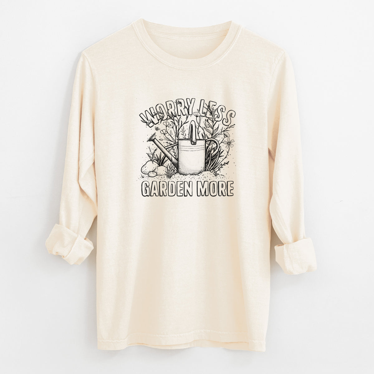 Ivory Comfort Colors long sleeve shirt laid flat with the cuffs rolled, printed with a black ink watering can surrounded by flowers and garden tools, with the words Worry Less, Garden More.