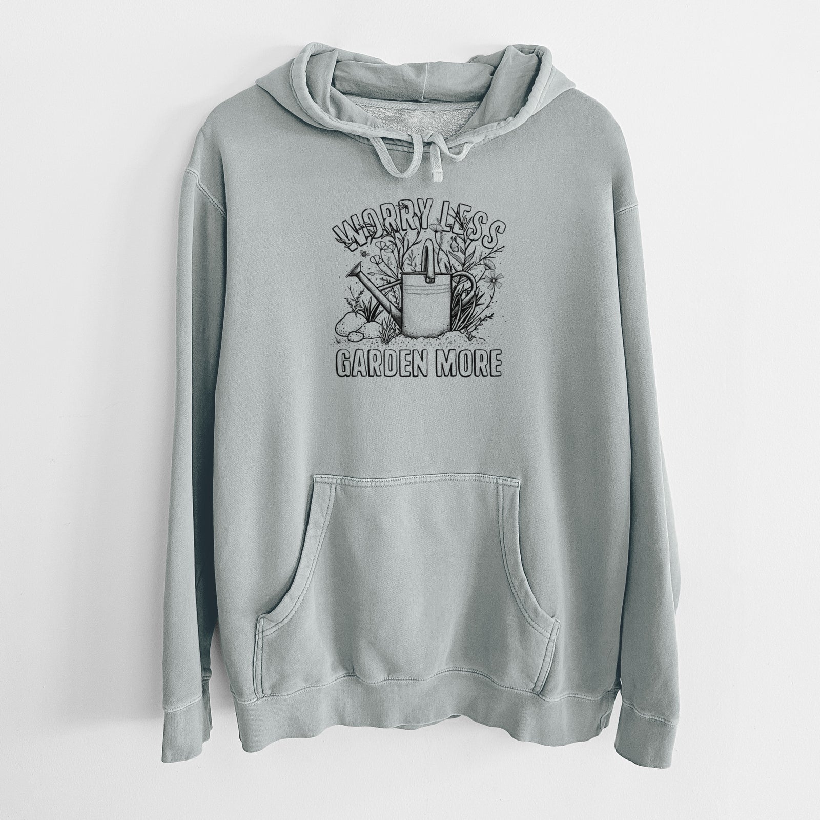 Sage green pigment dyed hoodie laid flat, printed with a black ink watering can surrounded by flowers and garden tools, with the words Worry Less, Garden More.