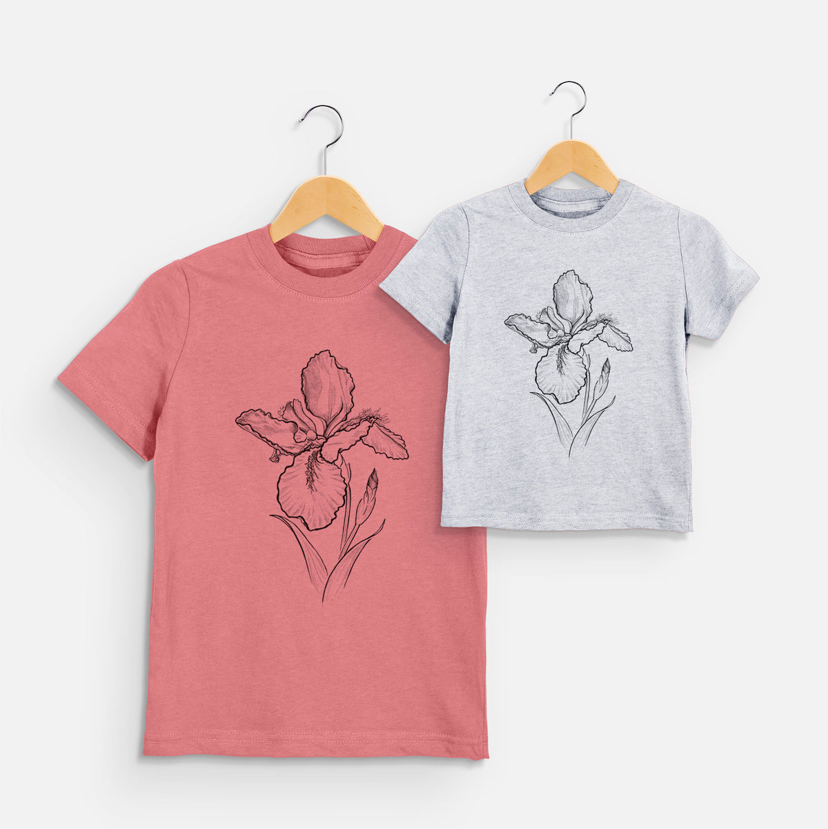 Two youth t-shirts in different colors on hangers, printed with a black ink line drawing of a wall iris flower on its stem.