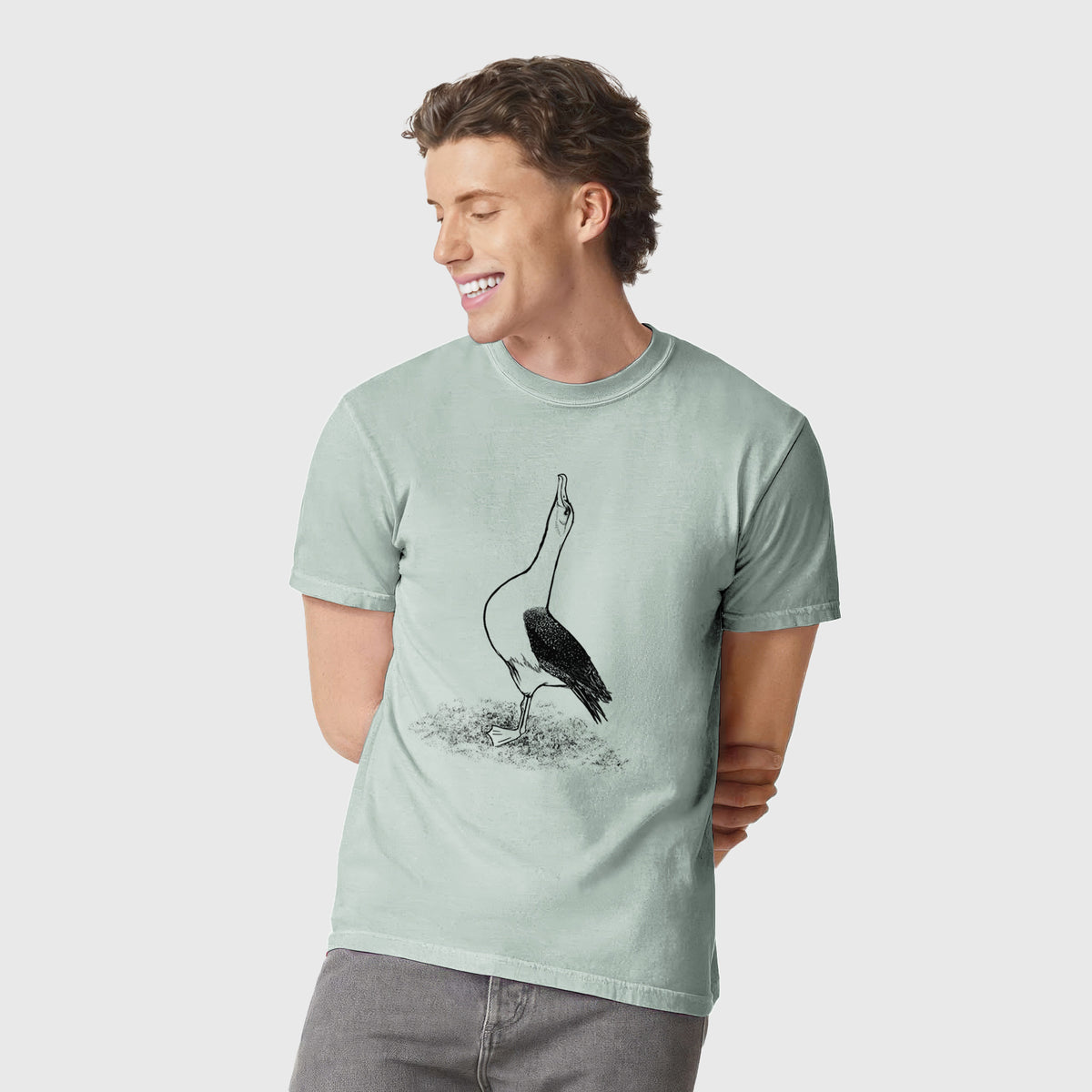 Man wearing a Comfort Colors t-shirt printed with a black ink illustration of a wandering albatross with its head raised.