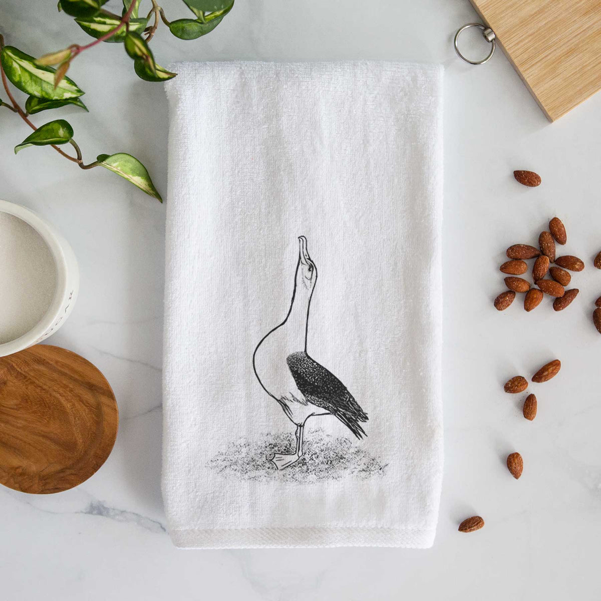 White hand towel printed with a black ink illustration of a wandering albatross with its head raised.
