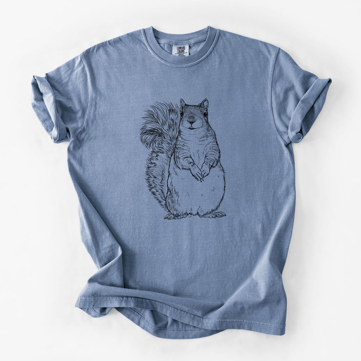 Blue jean Comfort Colors t-shirt laid flat, printed with a detailed black ink illustration of a western grey squirrel sitting upright with a bushy tail.