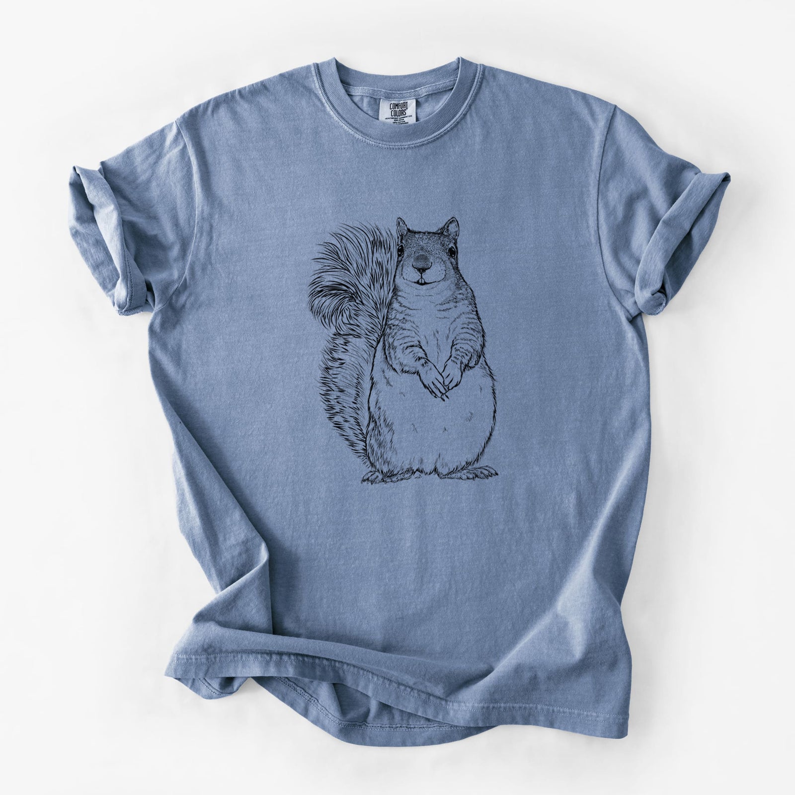 Blue jean Comfort Colors t-shirt laid flat, printed with a detailed black ink illustration of a western grey squirrel sitting upright with a bushy tail.