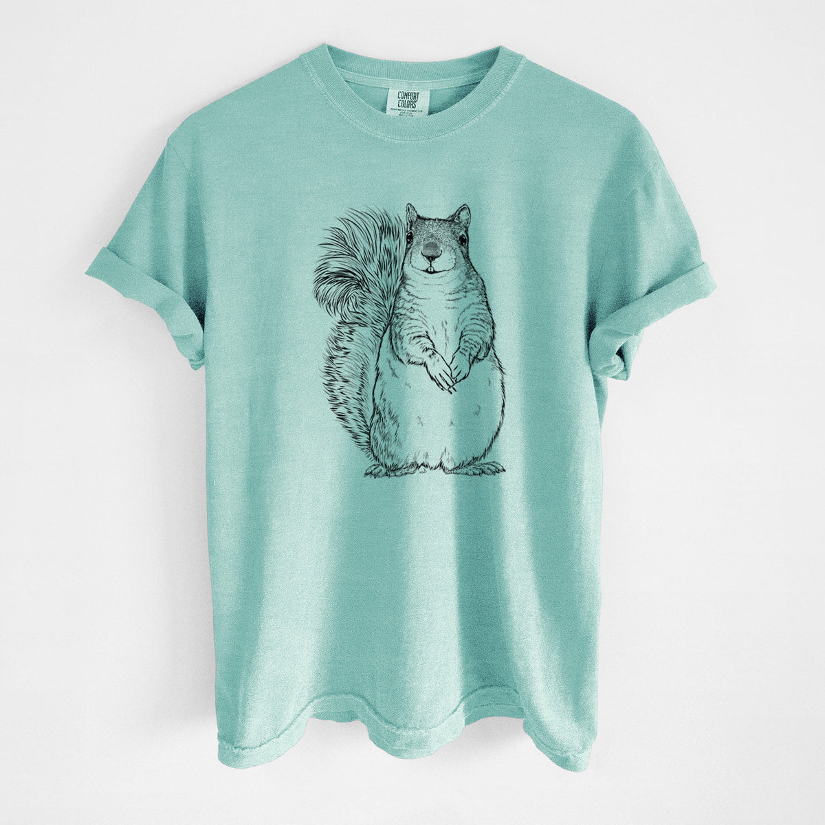 Chalky mint Comfort Colors t-shirt laid flat, printed with a detailed black ink illustration of a western grey squirrel sitting upright with a bushy tail.