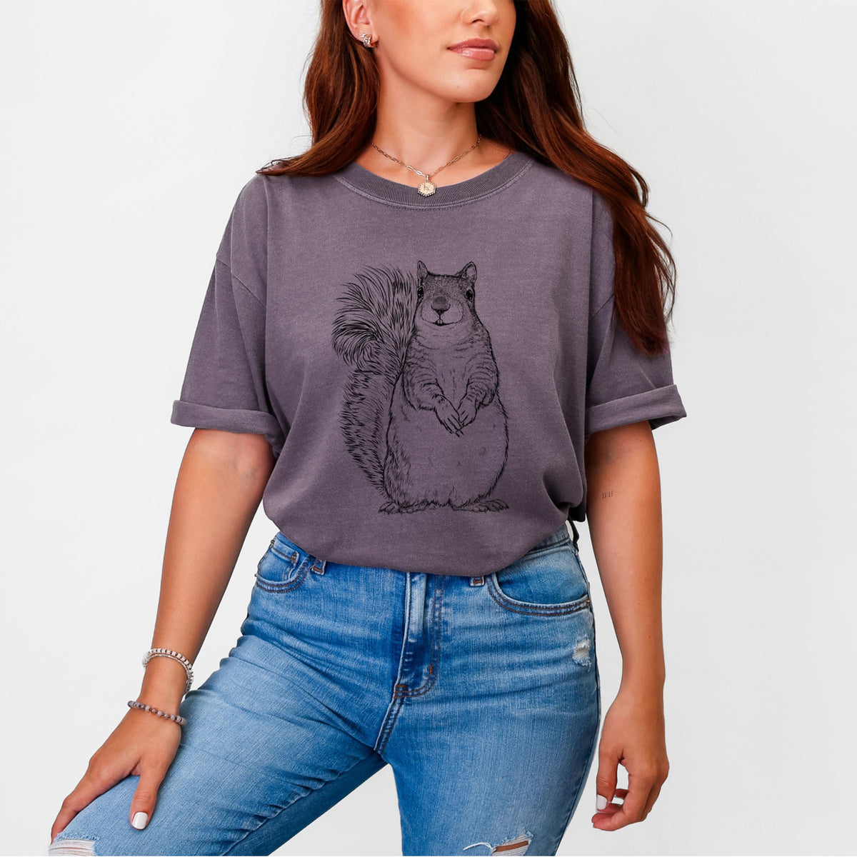 Woman wearing a Comfort Colors t-shirt printed with a detailed black ink illustration of a western grey squirrel sitting upright with a bushy tail.