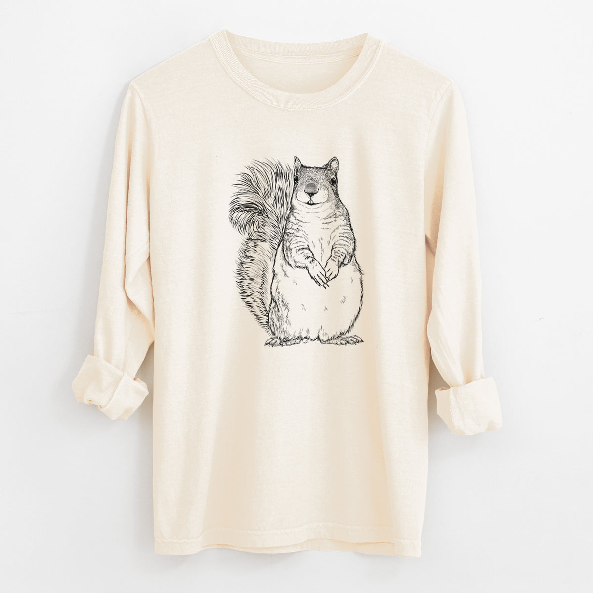 Ivory Comfort Colors long sleeve shirt laid flat with the cuffs rolled, printed with a detailed black ink illustration of a western grey squirrel sitting upright with a bushy tail.