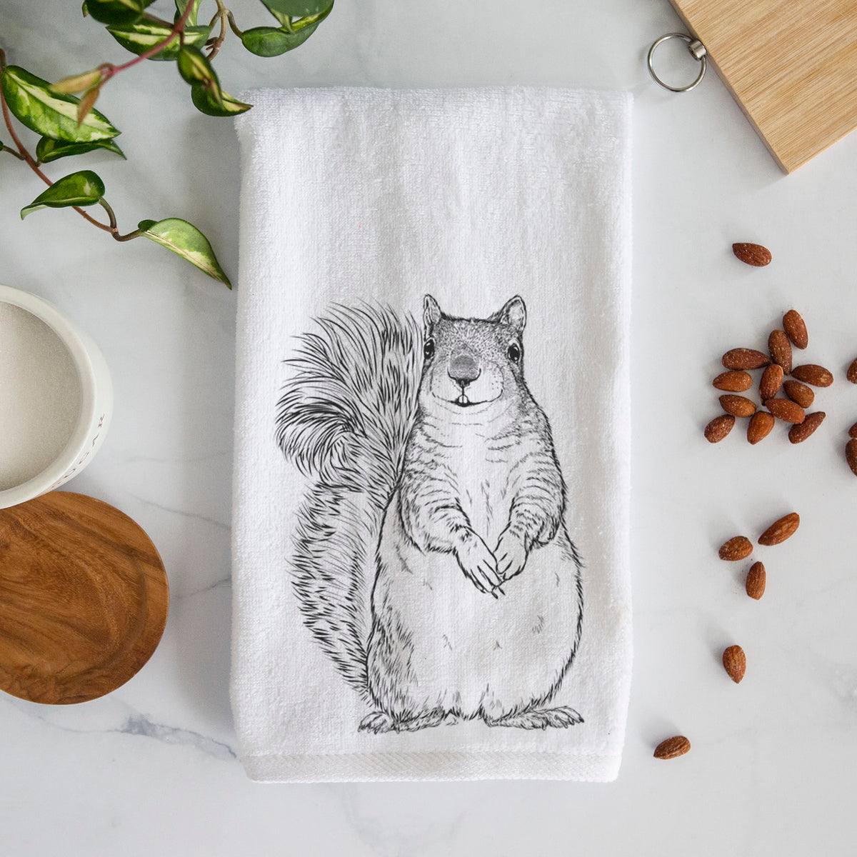 White hand towel printed with a detailed black ink illustration of a western grey squirrel sitting upright with a bushy tail.