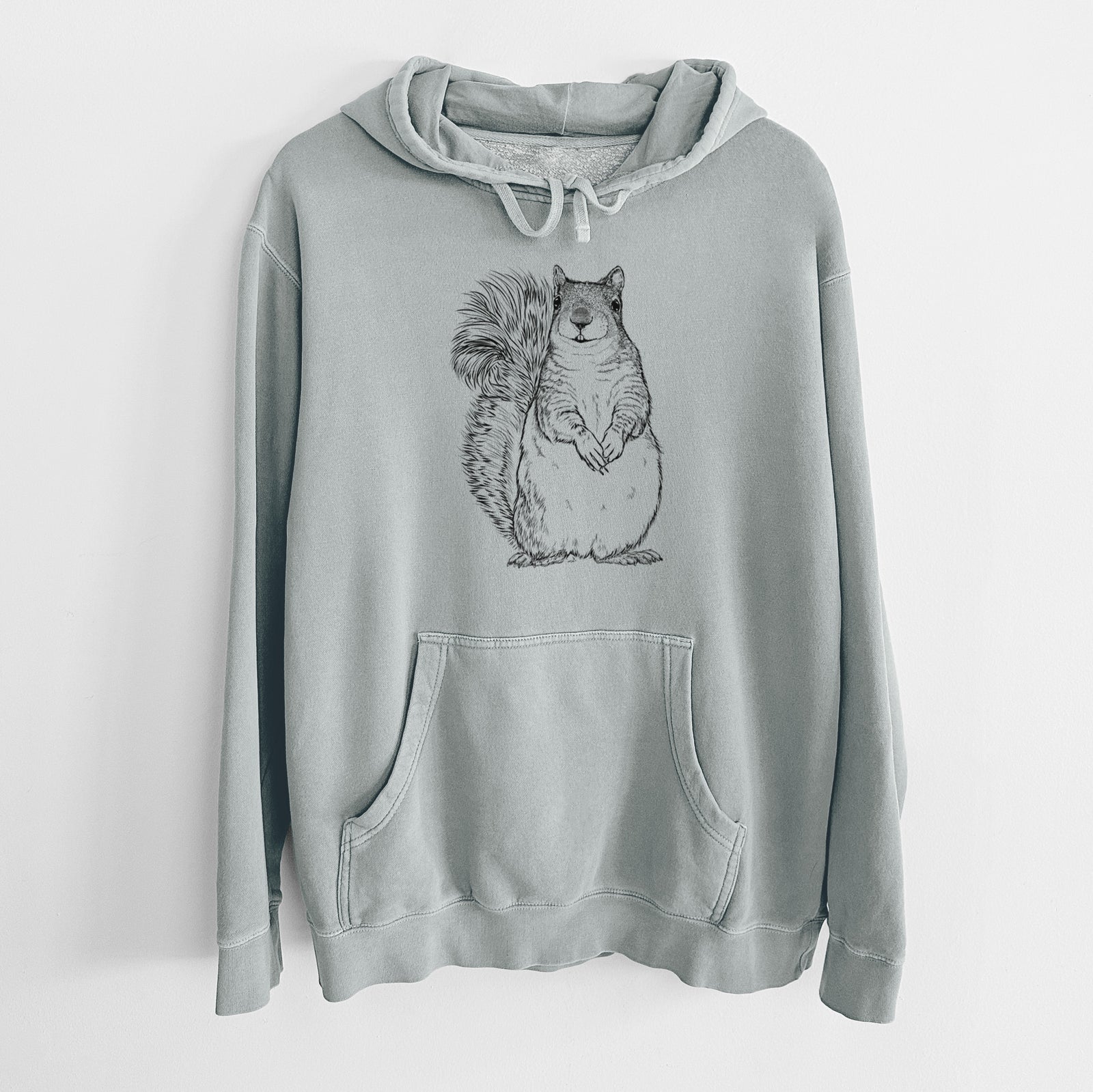 Sage green pigment dyed hoodie laid flat, printed with a detailed black ink illustration of a western grey squirrel sitting upright with a bushy tail.