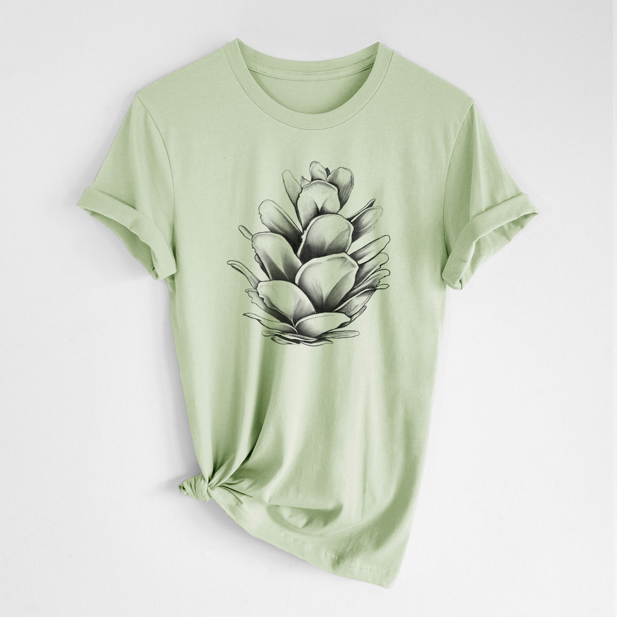 Spring green lightweight cotton t-shirt laid flat with the sleeves rolled, printed with a detailed black ink illustration of a western hemlock pine cone.
