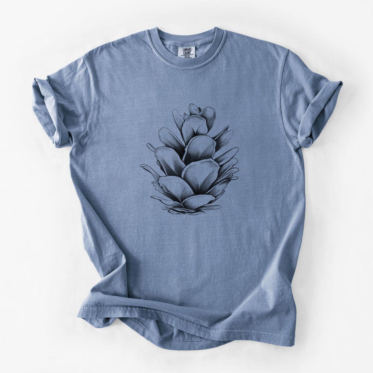 Blue jean Comfort Colors t-shirt laid flat, printed with a detailed black ink illustration of a western hemlock pine cone.