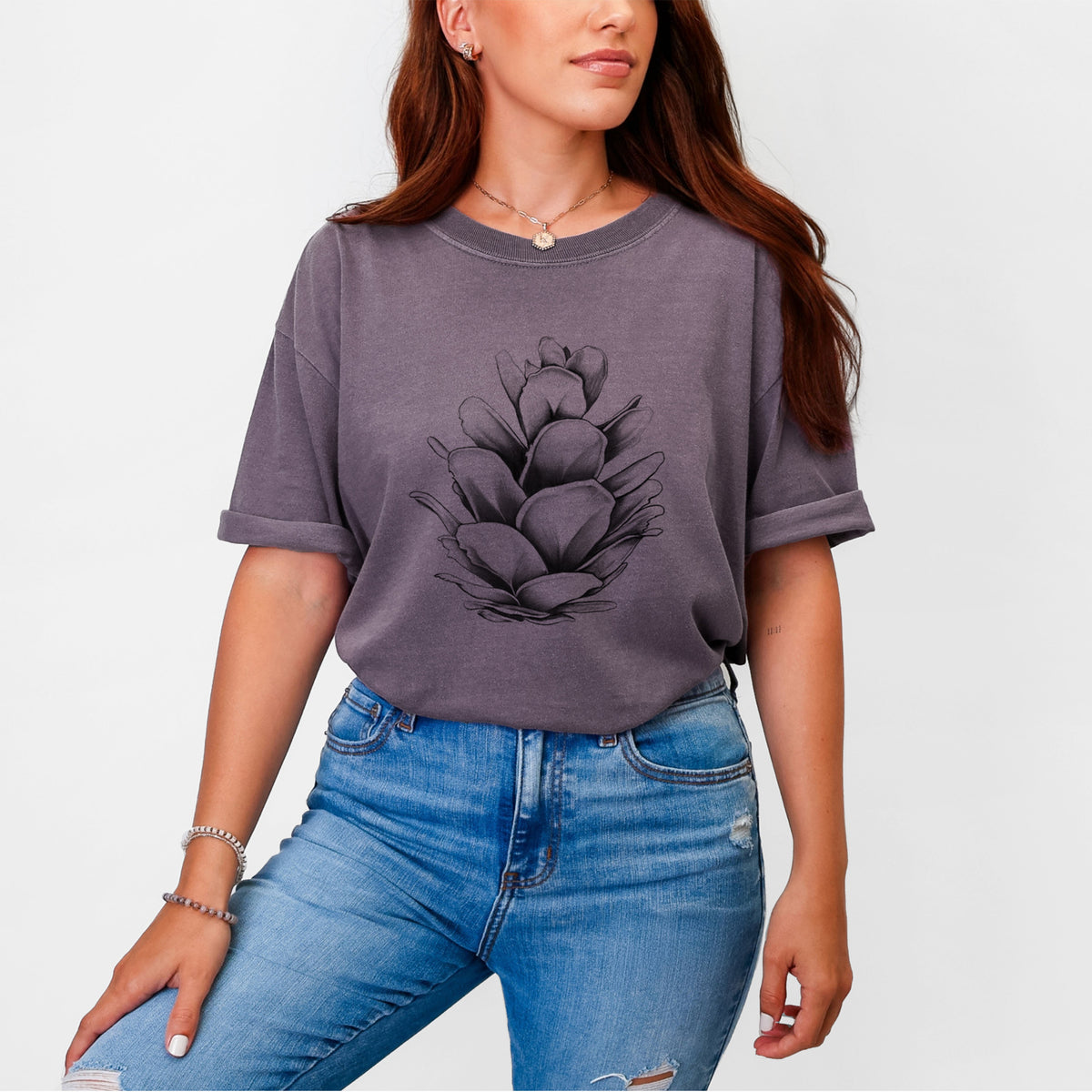 Woman wearing a Comfort Colors t-shirt printed with a detailed black ink illustration of a western hemlock pine cone.