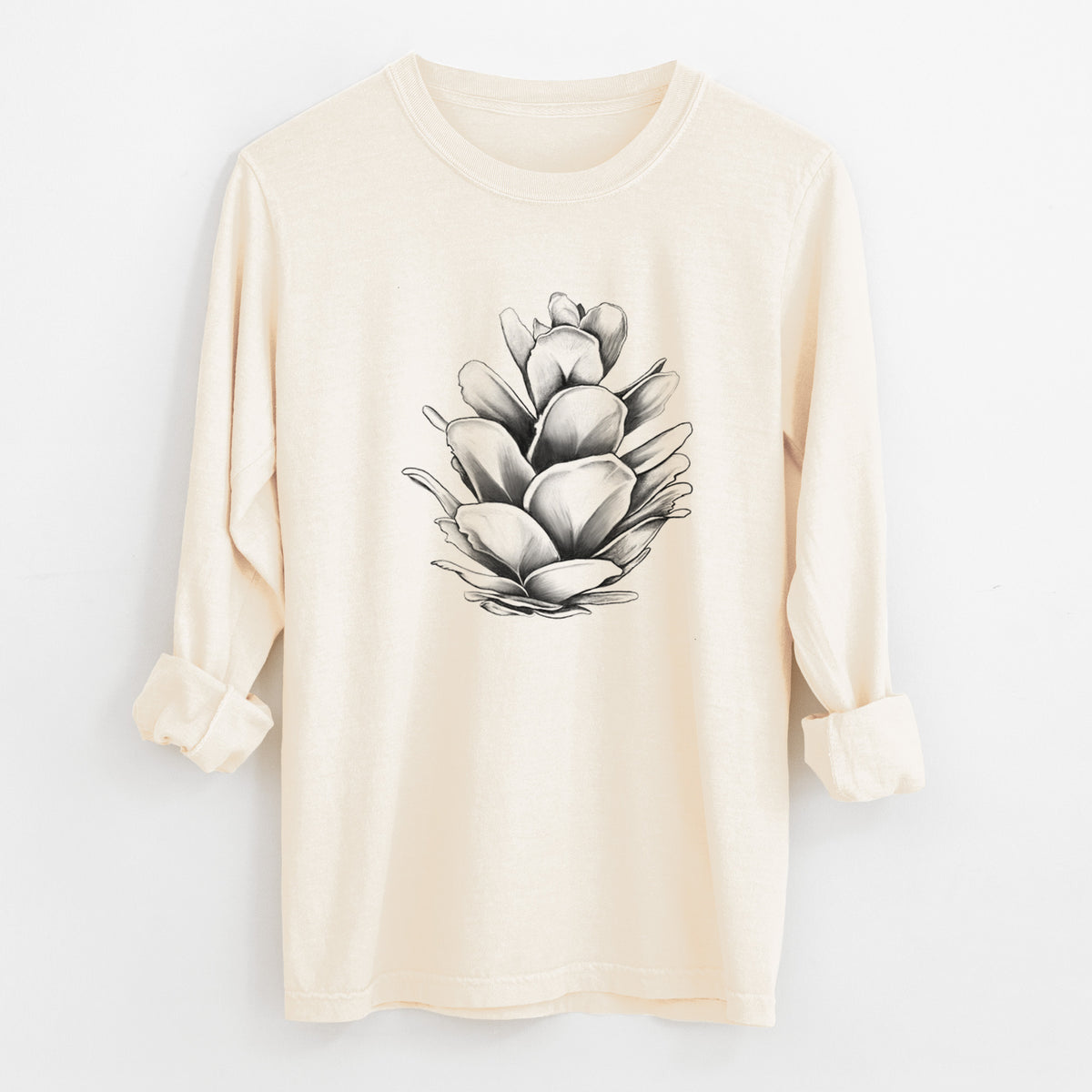 Ivory Comfort Colors long sleeve shirt laid flat with the cuffs rolled, printed with a detailed black ink illustration of a western hemlock pine cone.