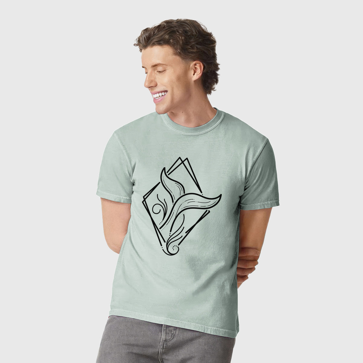 Man wearing a Comfort Colors t-shirt printed with a black line art whale tail rising from a wave inside a diamond outline.