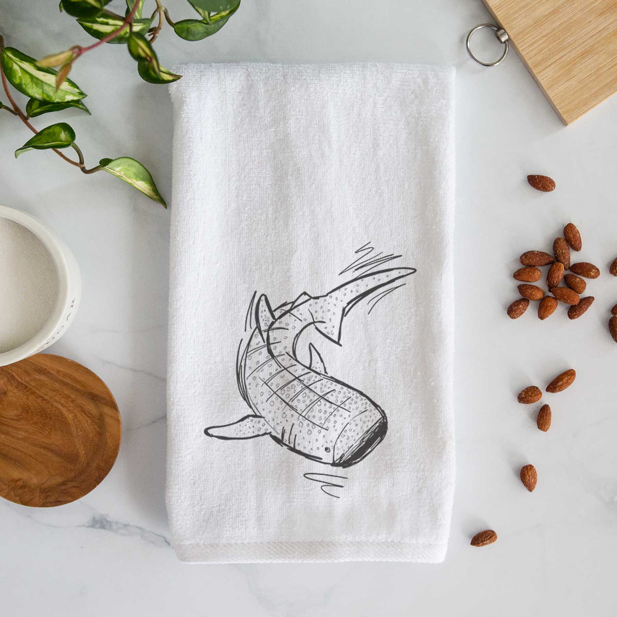 White hand towel printed with a black ink illustration of a spotted whale shark swimming.