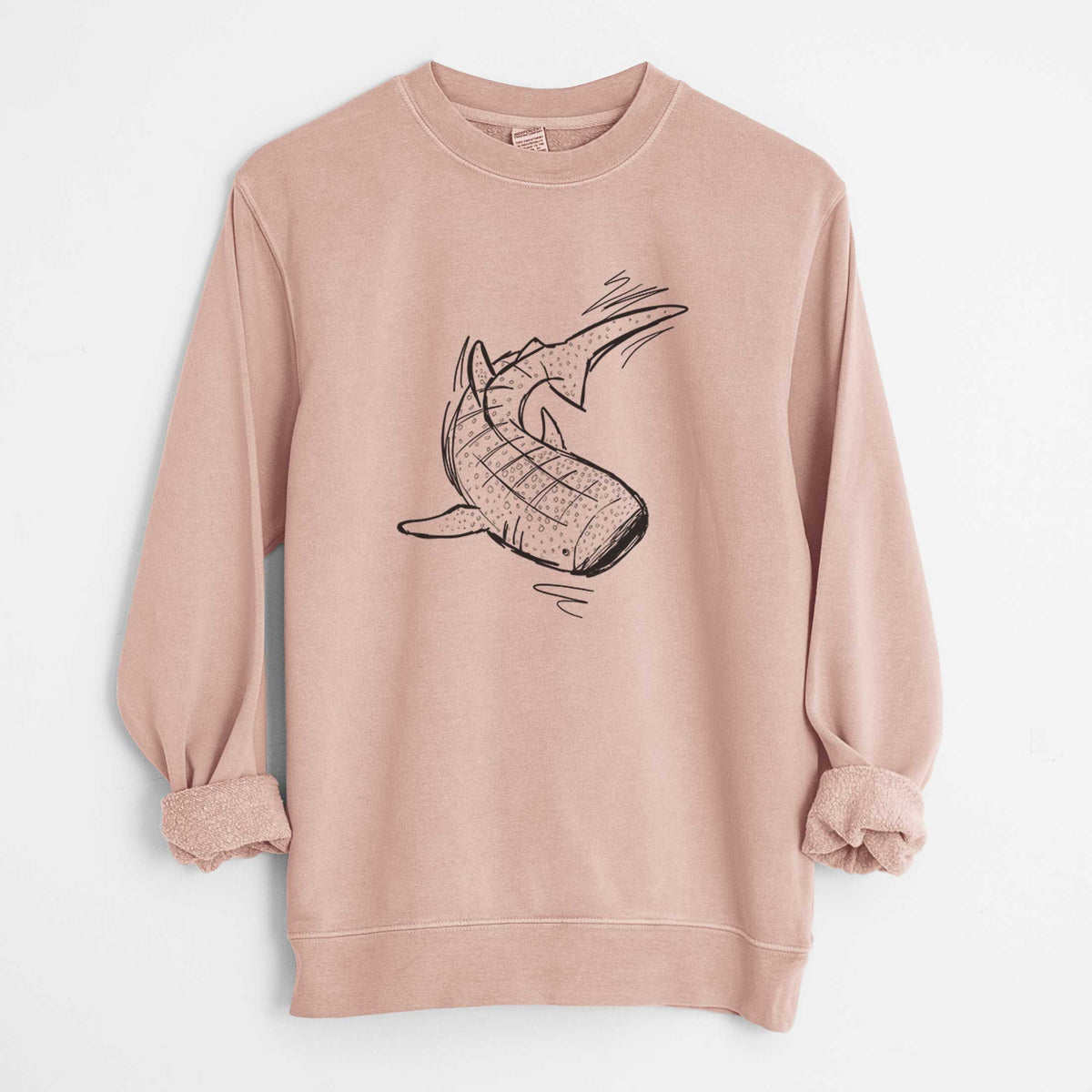 Dusty pink pigment dyed crewneck sweatshirt laid flat with the sleeves rolled, printed with a black ink illustration of a spotted whale shark swimming.