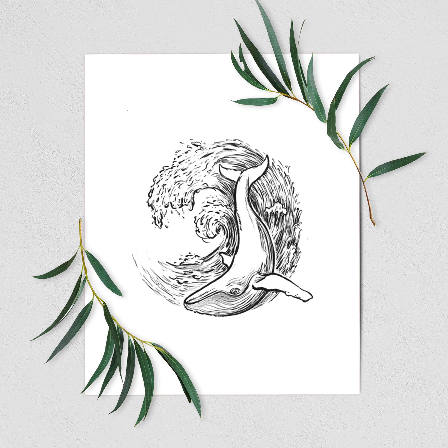Art print of a black ink illustration of a humpback whale swimming inside a curling ocean wave, shown with eucalyptus leaves.