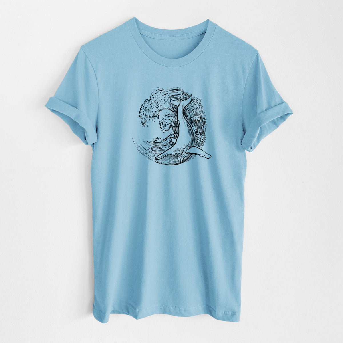 Ocean blue lightweight cotton t-shirt laid flat, printed with a black ink illustration of a humpback whale swimming inside a curling ocean wave.