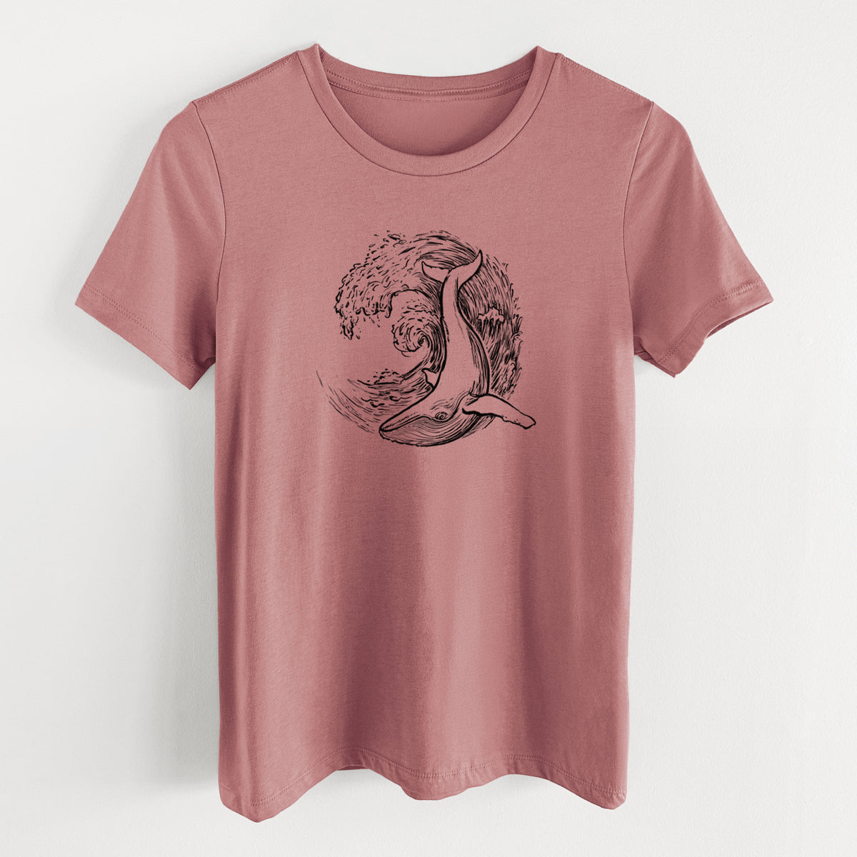 Mauve pink women's relaxed fit cotton t-shirt laid flat, printed with a black ink illustration of a humpback whale swimming inside a curling ocean wave.