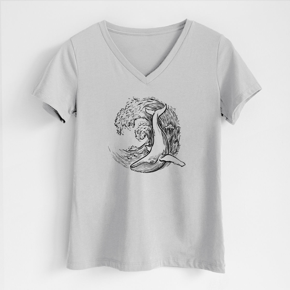 Lunar grey women's relaxed fit cotton V-neck t-shirt laid flat, printed with a black ink illustration of a humpback whale swimming inside a curling ocean wave.