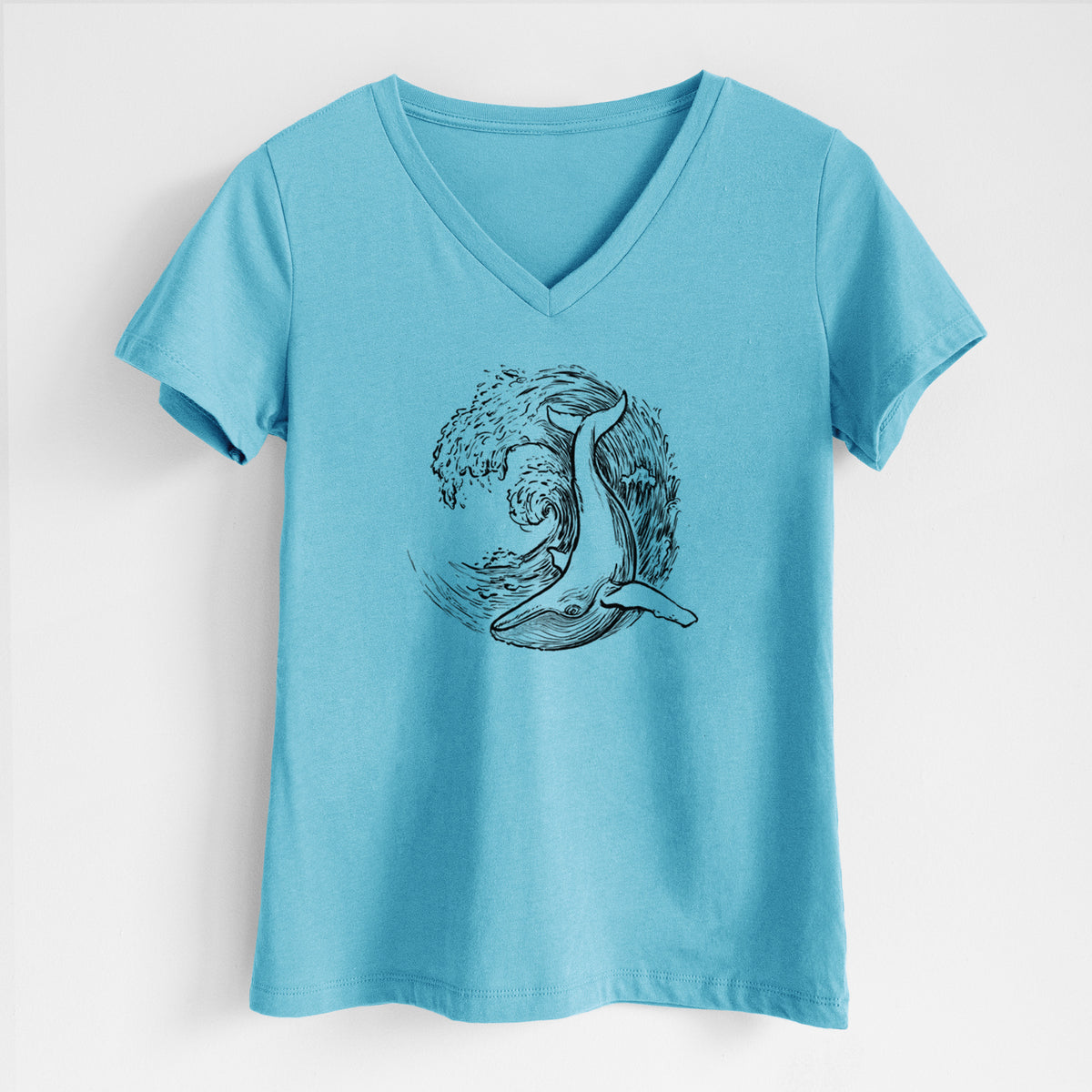Turquoise women's relaxed fit cotton V-neck t-shirt laid flat, printed with a black ink illustration of a humpback whale swimming inside a curling ocean wave.
