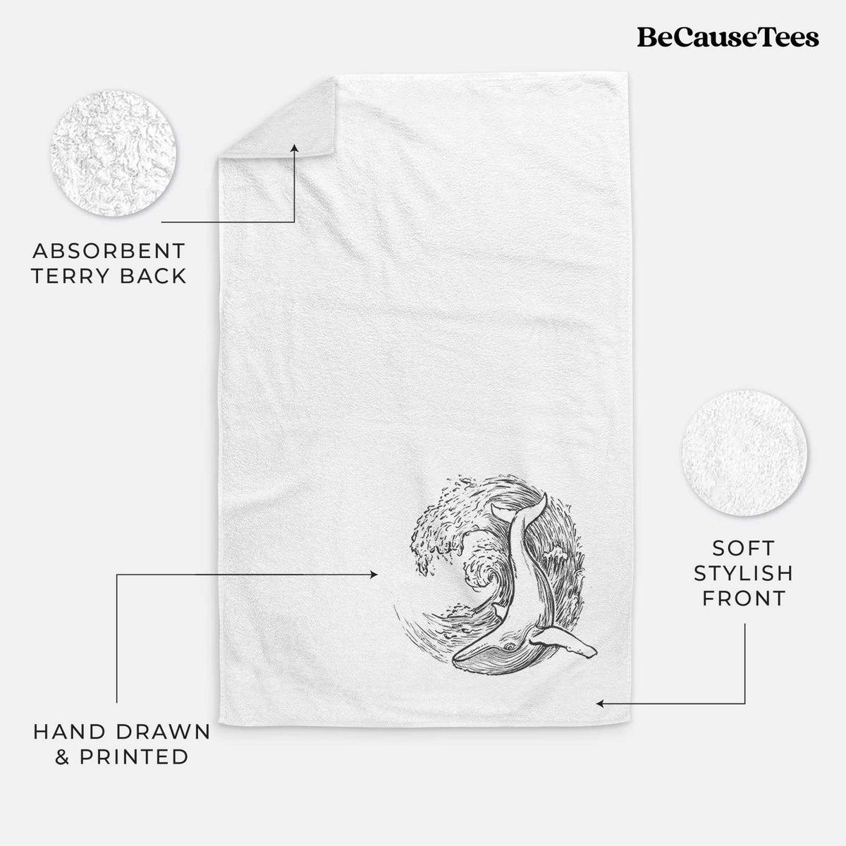 White hand towel printed with a black ink illustration of a humpback whale swimming inside a curling ocean wave.