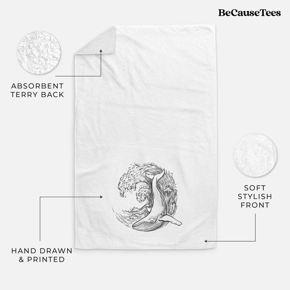 White hand towel printed with a black ink illustration of a humpback whale swimming inside a curling ocean wave.