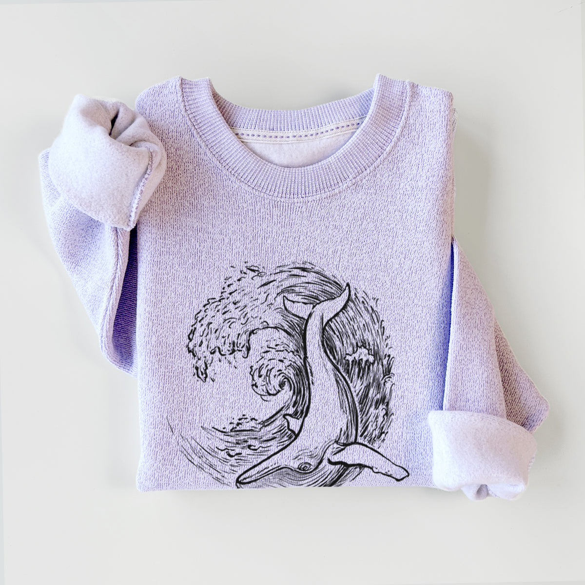 Ice purple knit sweatshirt printed with a black ink illustration of a humpback whale swimming inside a curling ocean wave, styled flat.